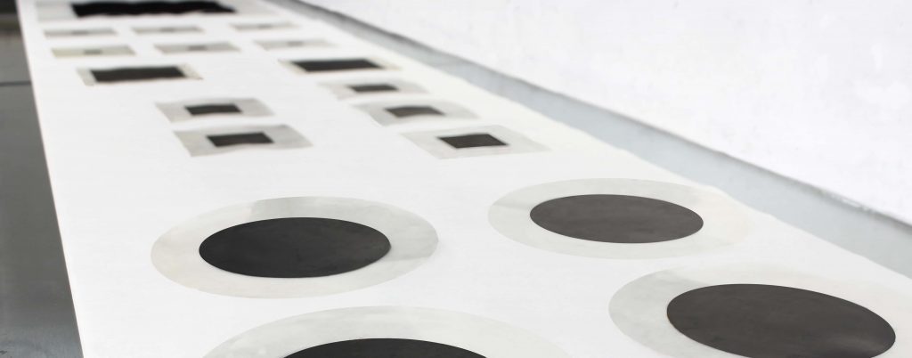Rows of membrane electrode assemblies with circular and square catalyst areas on a production table
