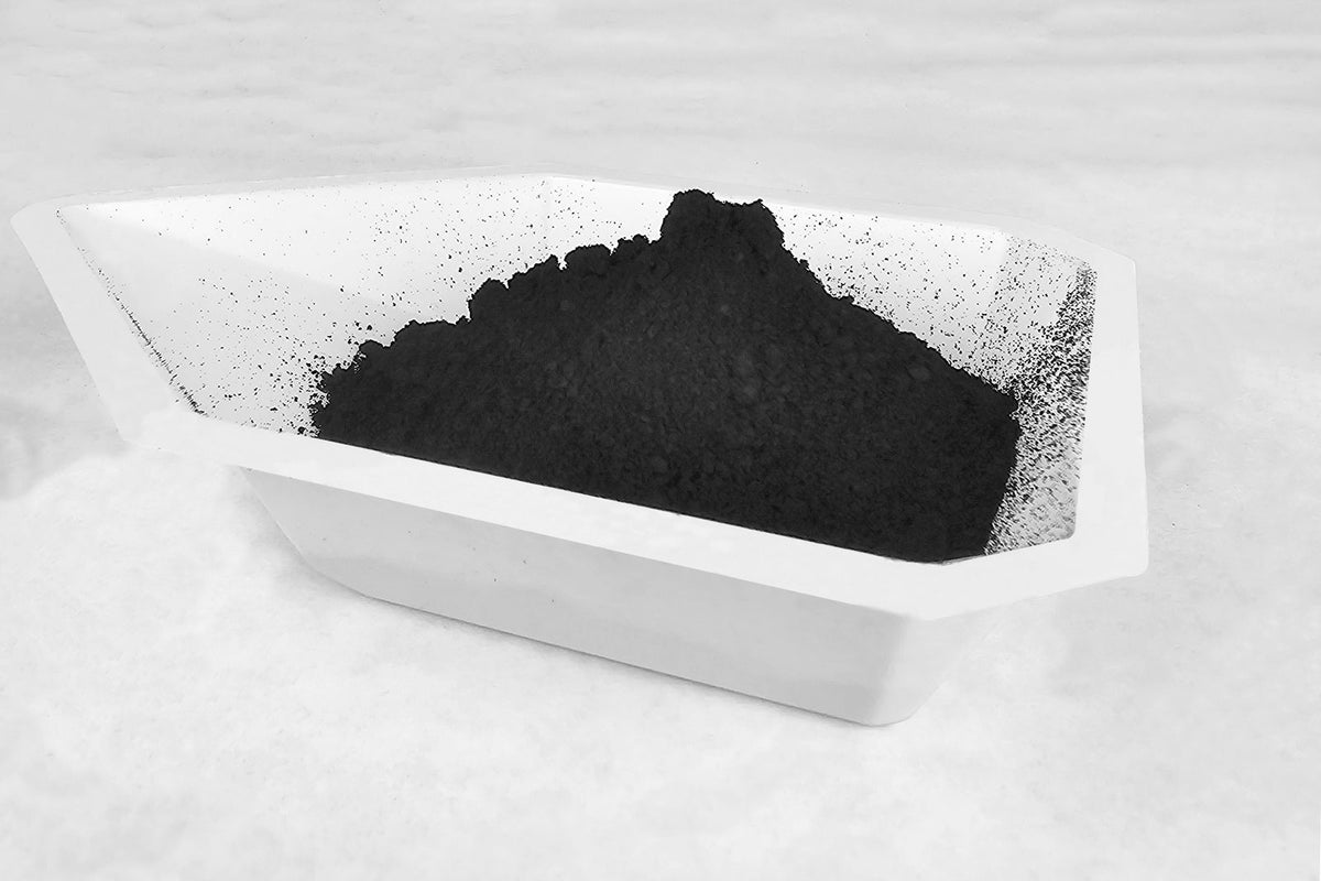 Black carbon-supported catalyst powder in a white weigh boat